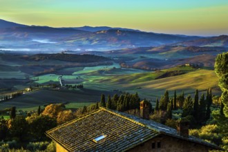 Predawn dusk. The sky is turning pink over the hills. Picturesque valley in central Italy. Tuscany.