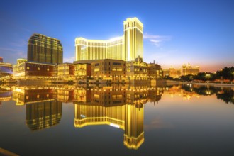 Scenic panorama cityscape of Macau, China, reflected on lake at sunset. Urban night scene, Asia