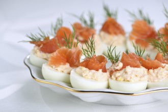 Appetizer of stuffed eggs stuffed with salmon pate and yolks with salmon slices. Holiday table idea