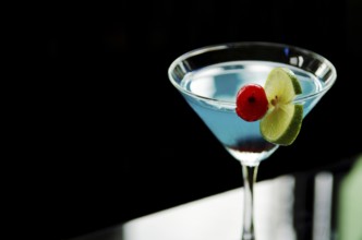 Blue cocktail drink with cherry and lime