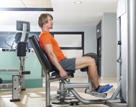 Hip abduction blond man exercise at gym indoor closing legs workout