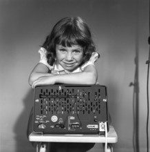 In the 1950s. A girl with a Philips radio set with the backside of the radio visible where the