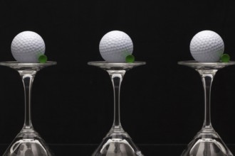 Three glasses of champagne with golf balls