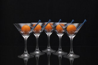 Five glasses of champagne with golf balls