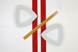 Ceramic bowls and bamboo chopsticks for sushi food with on the white wooden table.Top view. Flat