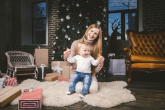 Young mother and son playing near Christmas tree. young mother and son playing near the Christmas