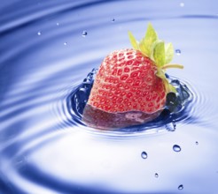 Blue water drop closeup with strawberry incide