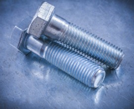 Metal threaded bolts on metallic background construction concept