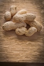 Small stack of peanuts on vintage wooden board food and drink concept