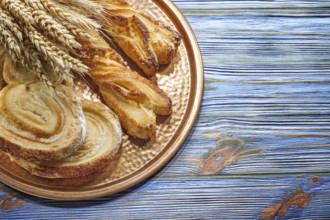 Wheat ears crusty rolls brass tray on vintage wooden board