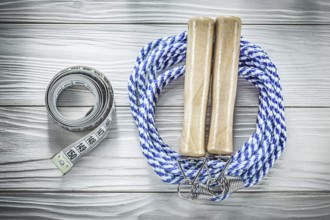Rolled skipping rope tape measure on wooden board fitness concept