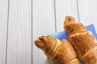 Two croissants on old white wooden boards with copyspace
