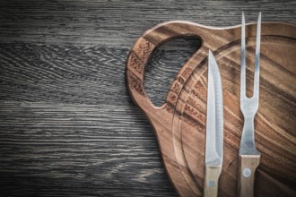 Meat fork knife chopping board on vintage wooden background
