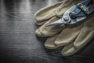 Safety gloves steel scissors on wooden board