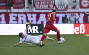 Football match, Ritsu DOAN SC Freiburg left, lying down, tries to separate Jonas FÖHRENBACH 1.FC