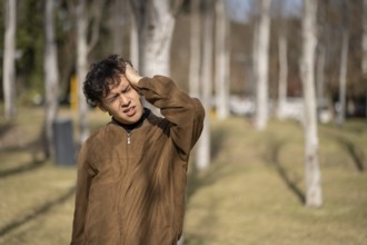 Stressed and tired young man touches his head because of a headache