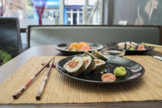 Sushi in sushi bar. Table and ration sushi