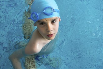 Little boy in swimming pool. Blue swimming pool