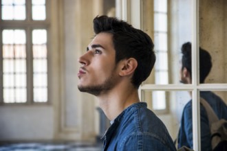 Half Body Shot of a Thoughtful Handsome Young Man Looking Away out of Window, Inside Historic