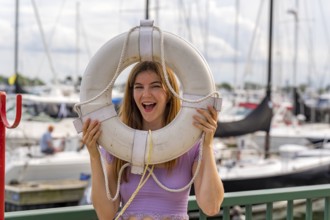 A gorgeous redhead model enjoys the perfect summer weather at a local marina, surrounded by boats