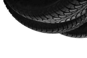 Isolated on white, three bottoms of new black rubber automobile tires with protector