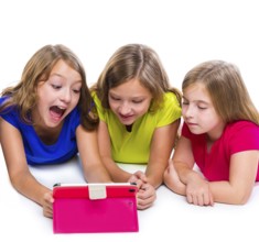 Sisters cousins kid girls with tech tablet pc playing happy lying on white background