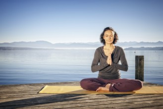 An image of a pretty woman doing yoga at the lake