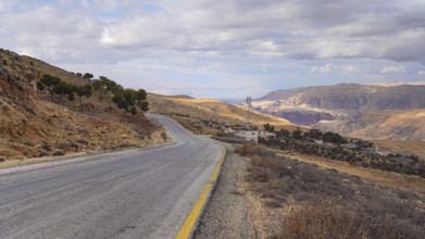 Road in mountainous terrain near At Tafilah, Jordan, Dead Sea at distant background, Asia
