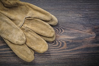 Pair of leather protective gloves on wooden board gardening concept