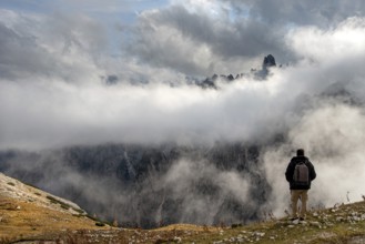 Man arms outstretched at sunrise enjoying landscape freedom and life. Tre cime di lavadero Italian
