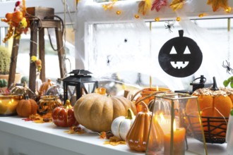 Festive decor of the house on the windowsill for Halloween, pumpkins, Jack o lanterns, skulls,