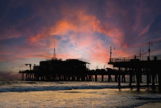 Silhouette of a roller coaster at sunset on a California coastline