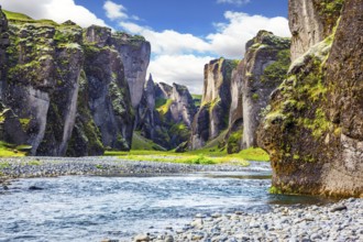 Steep cliffs, overgrown with green moss, surrounded by a very fast river with cold water. Magic
