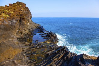 Small bay with azure water. Volcanic island of Madeira. Grottoes and rocks of the Atlantic coast.