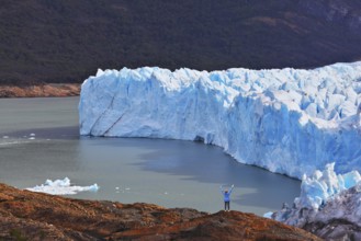 The woman - tourist admire the white-blue icy splendor. Giant lake Perito Moreno glacier