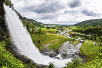 Huge bubbling waterfall Steinsdalsfossen. Summer day in the mountains of Norway. Exciting adventure