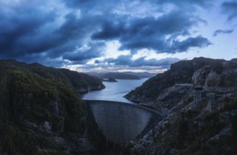 An aerial view of the Gordon Dam on a cool summer's day. It is a unique double curvature concrete