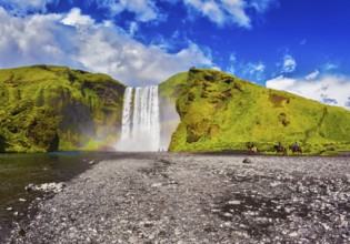Huge waterfall flowing from under giant glacier. Iceland, waterfall Skogafoss summer, clouds of