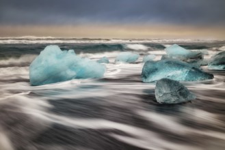 Ice floes on the black sea sand and the coast Jokulsarlon