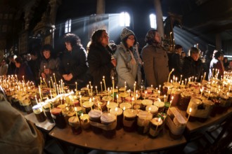 Blagoevgrad, Bulgaria - February 10, 2019: Worshippers light candles on jars with honey during a
