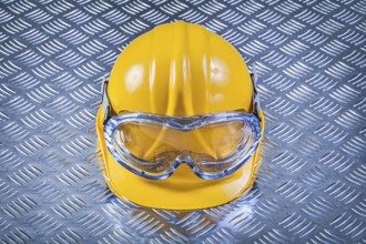 Safety glasses hard hat on grooved metal plate construction concept