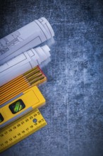 Blueprints yellow ruler construction level and wooden meter on metallic scratched background