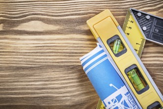 Blue construction plan level square ruler on wooden board