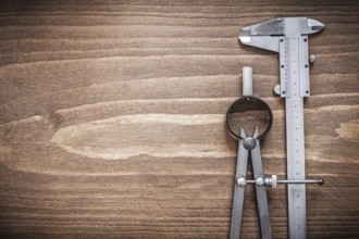 Slide caliper divider on wooden board copyspace construction concept