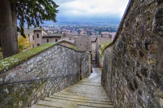 Narrow cobblestone trail leads to the top of the hill. Autumn cloudy day. Magnificent Italy. The