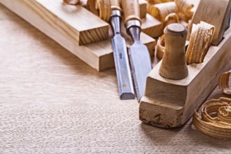 Veri close up view old fashioned plane chisels planks shavings on wooden board