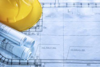 Protective hard hat construction drawings on blueprint