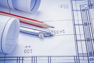 Rolled blueprints pencil compass close up