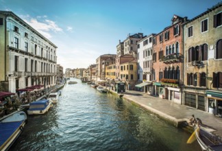 Ancient buildings and boats in the channel in Venice