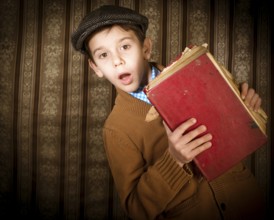 Child with red vintage book. Vintage clothes and hat